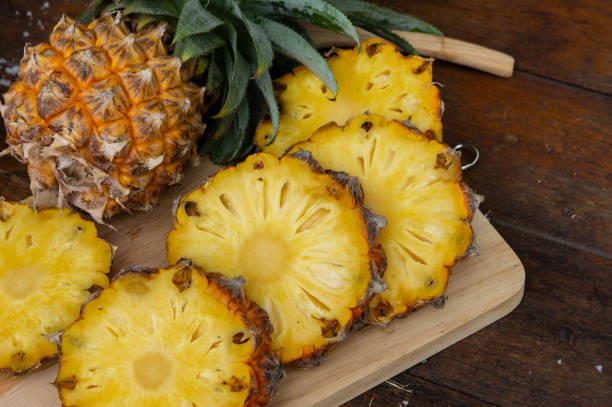 Ananas coupé en tranches sur une planche à découper