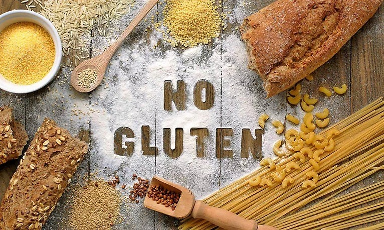 Une table rustique en bois où l’on trouve toutes sortes de produits provenant des céréales comme les pâtes et le pain. Écrite avec la farine NO GLUTEN.